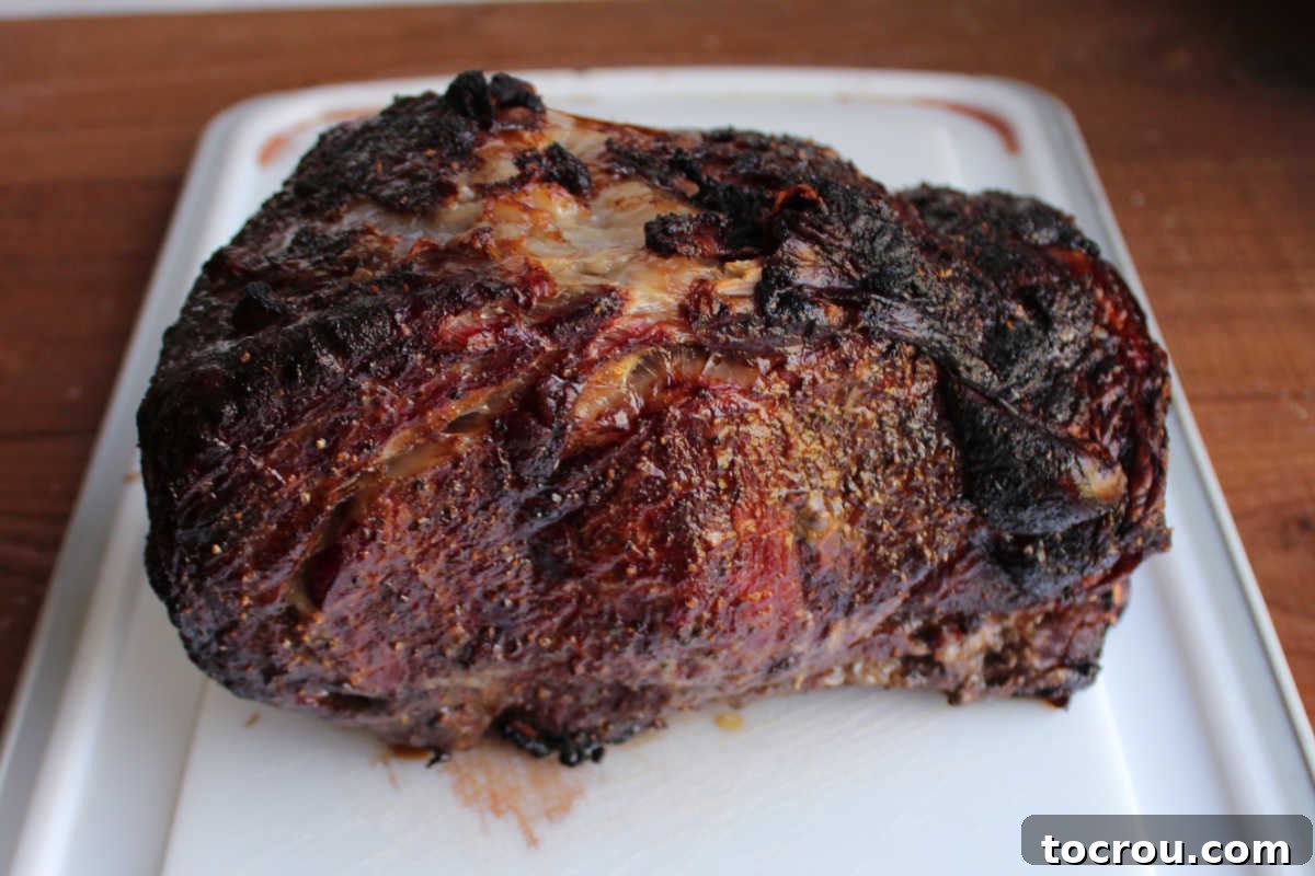 Smoked prime rib resting on cutting board, ready to be sliced.