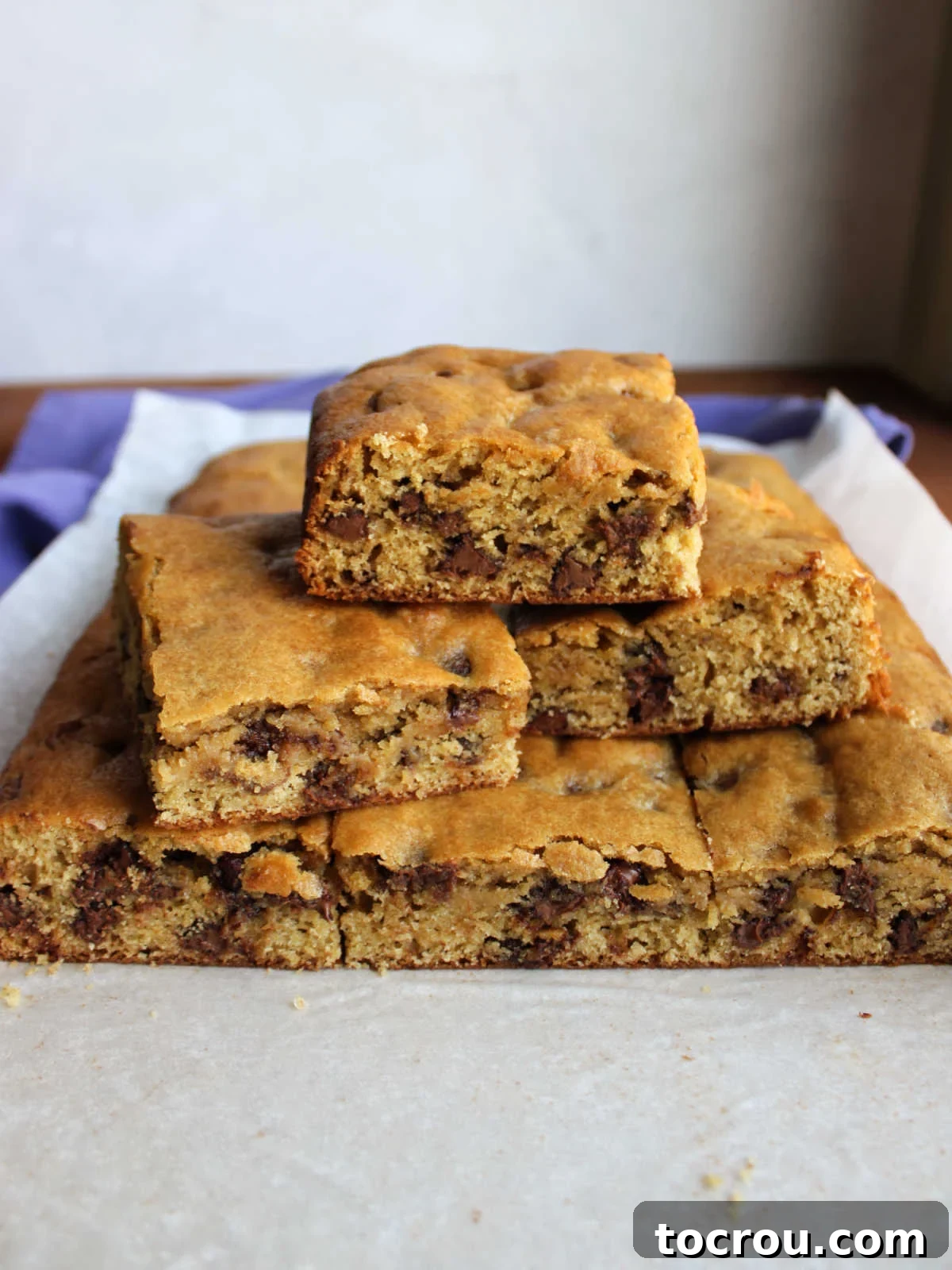 Delicious squares of sourdough chocolate chip cookie bars artfully arranged on a cutting board, ready for enjoyment.