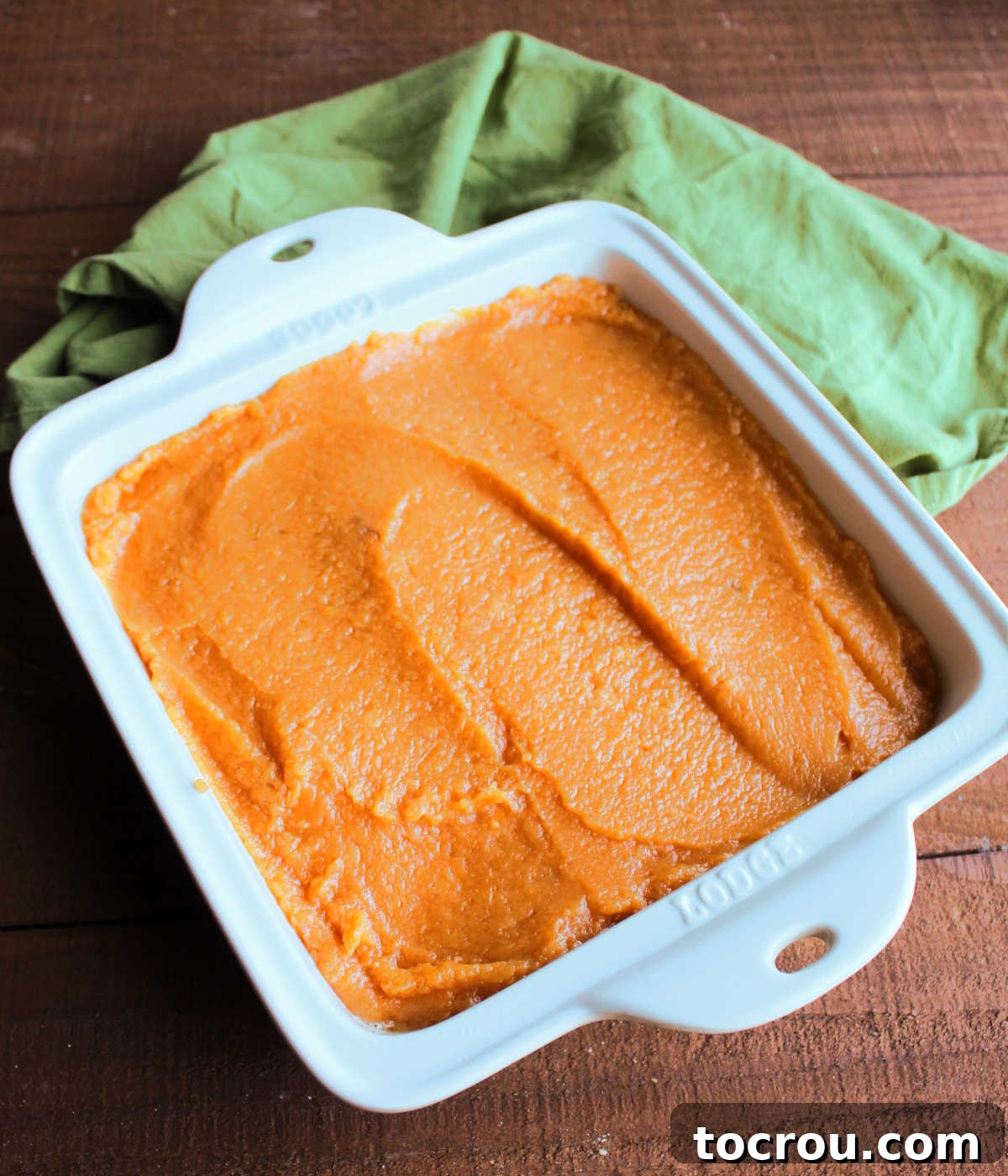 Smooth sweet potato and maple syrup layer in square baking dish.