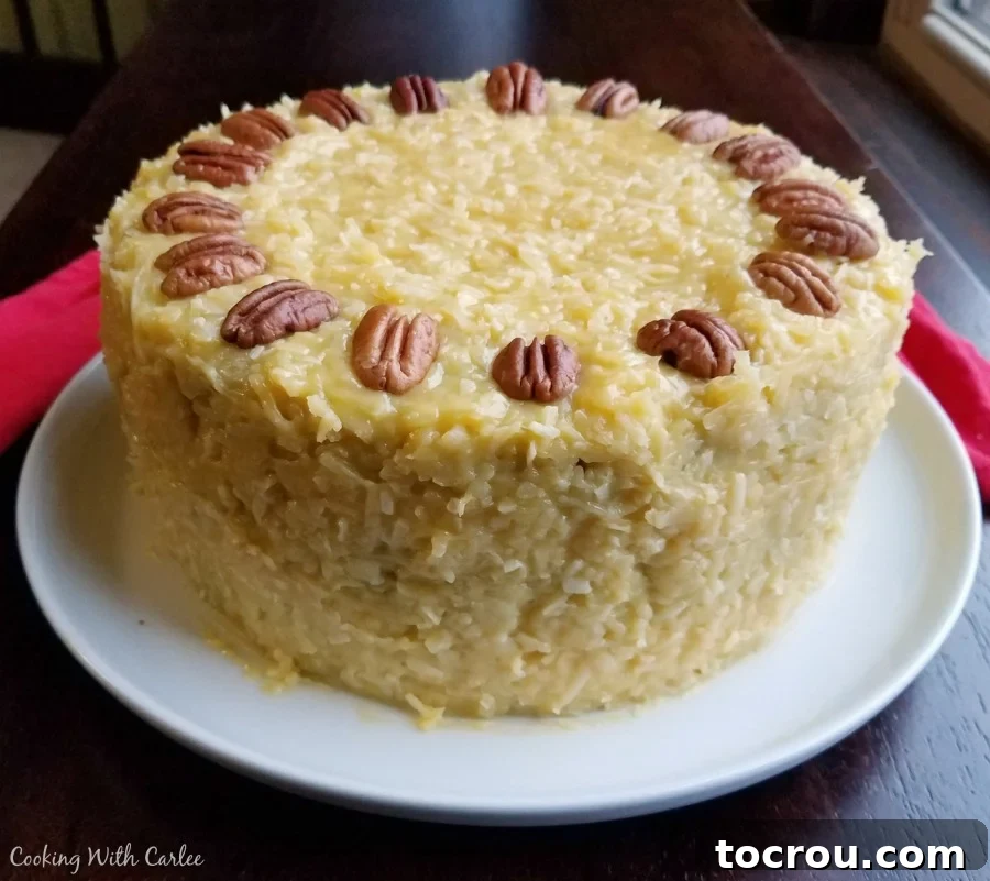 Whole German Chocolate Cake, a showstopper for any party! Whole German Chocolate Cake beautifully decorated with gooey coconut-pecan frosting and whole pecan halves on top.