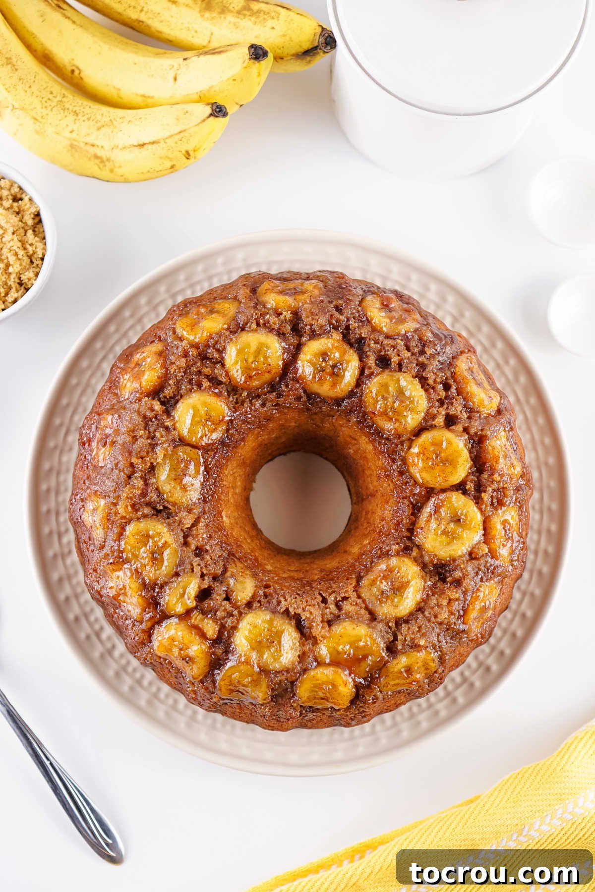 Whole banana upside down bundt cake after it has been baked and turned out from the pan showing the banana slices and brown sugar mixture on top.