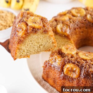 Spatula lifting slice of upside down banana bundt cake with banana and brown sugar topping and moist interior showing.