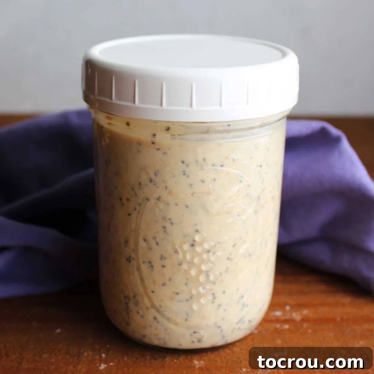Wide mouth jar filled with peanut butter overnight oats, ready to be enjoyed.