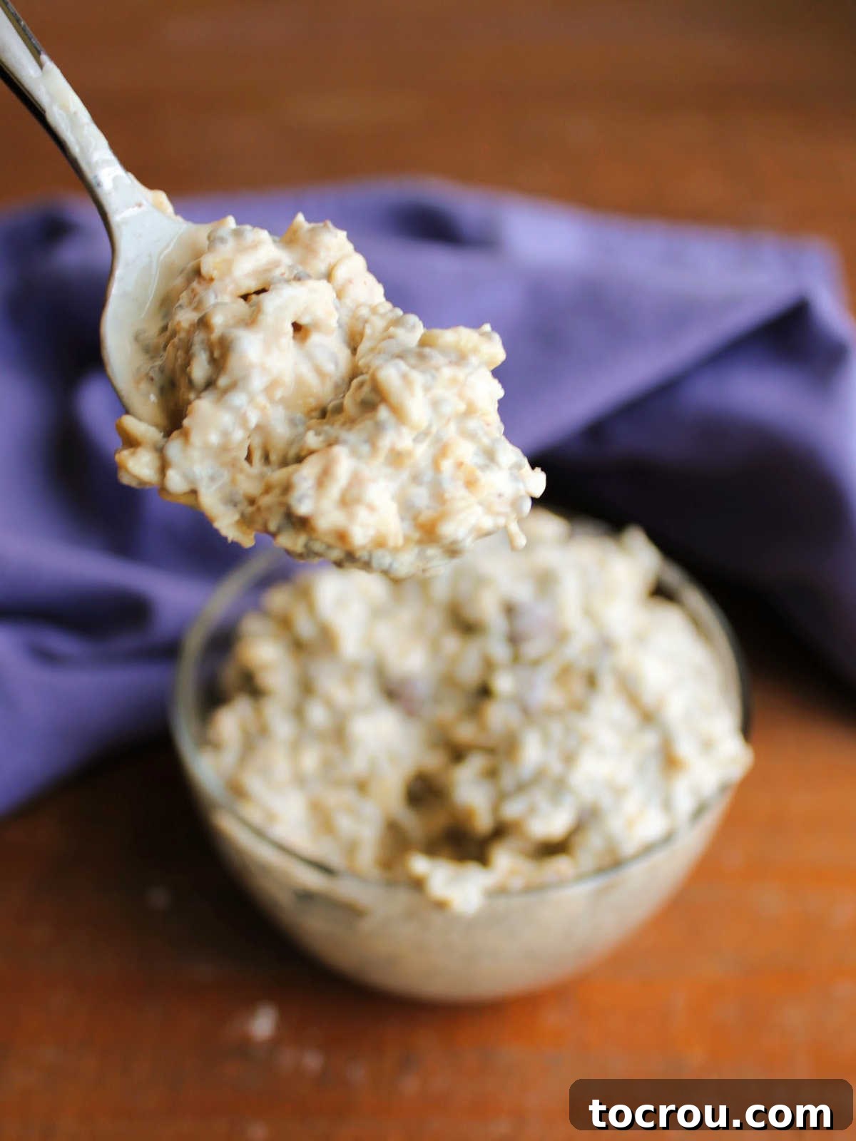 Bite of peanut butter overnight oatmeal on spoon, ready to eat. 