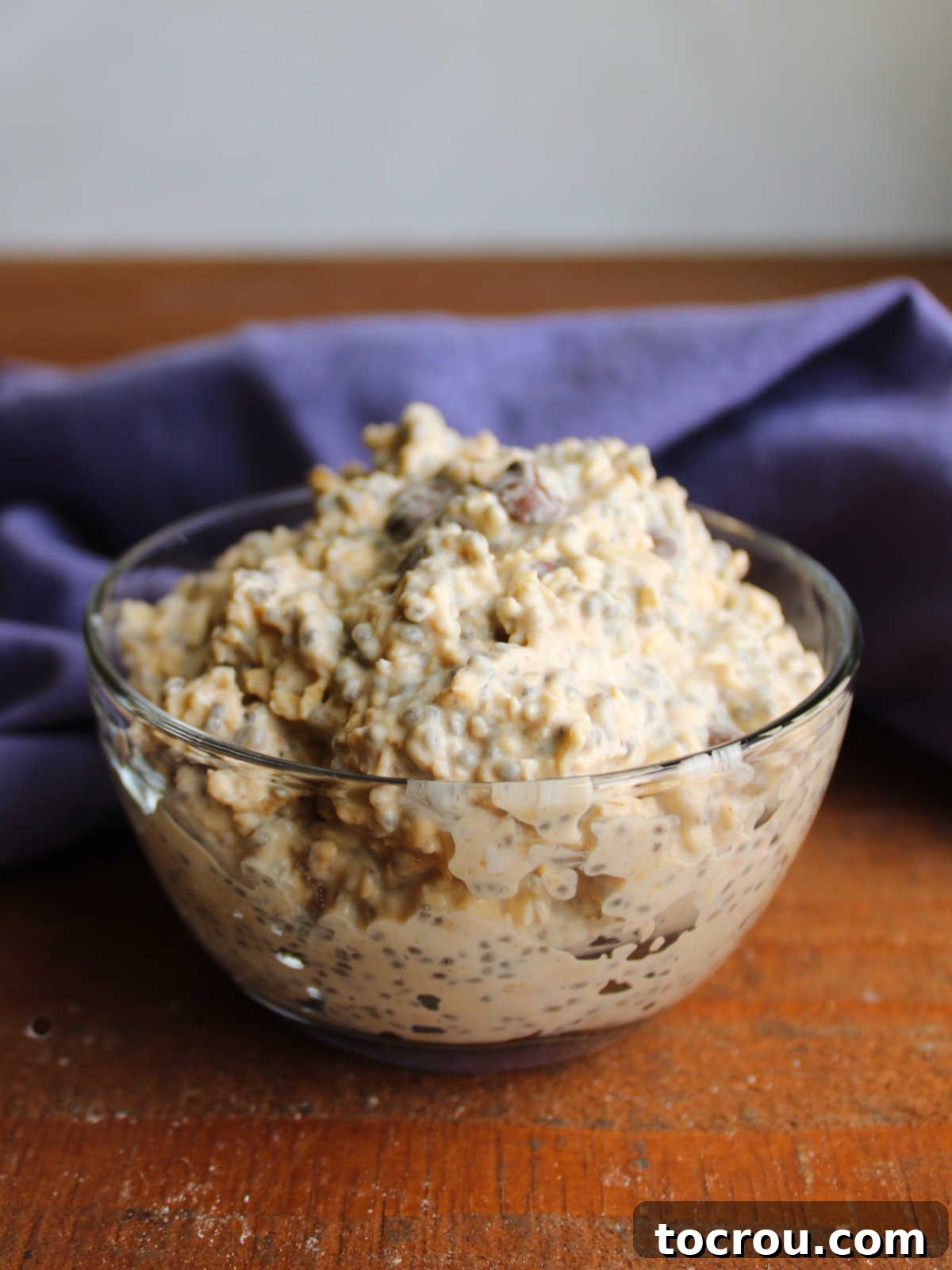 Bowl of peanut butter overnight oats with chia and chocolate chips mounded over bowl showing how thick they are after the liquid has been absorbed. 