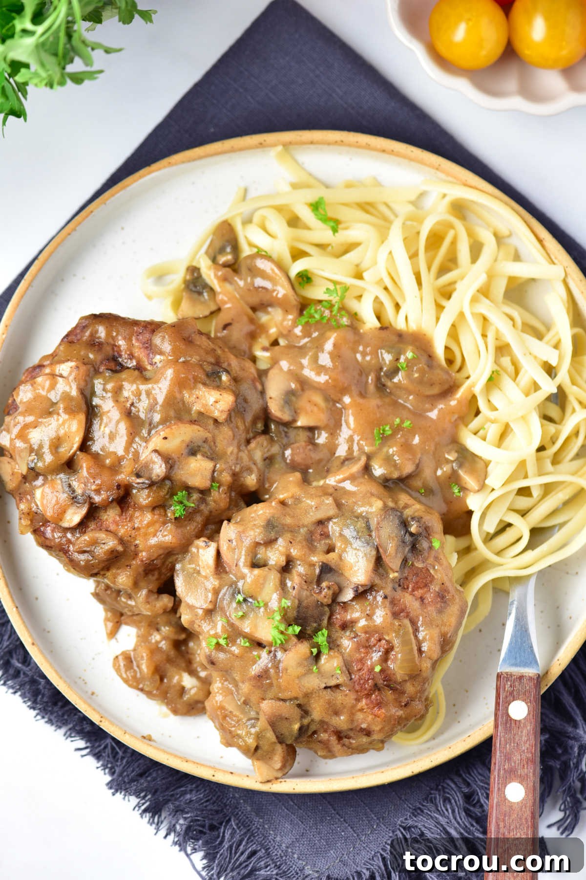 Served Turkey Salisbury Steaks Dinner plate with ground turkey salisbury steaks in mushroom gravy served with egg noodles, ready for dinner.
