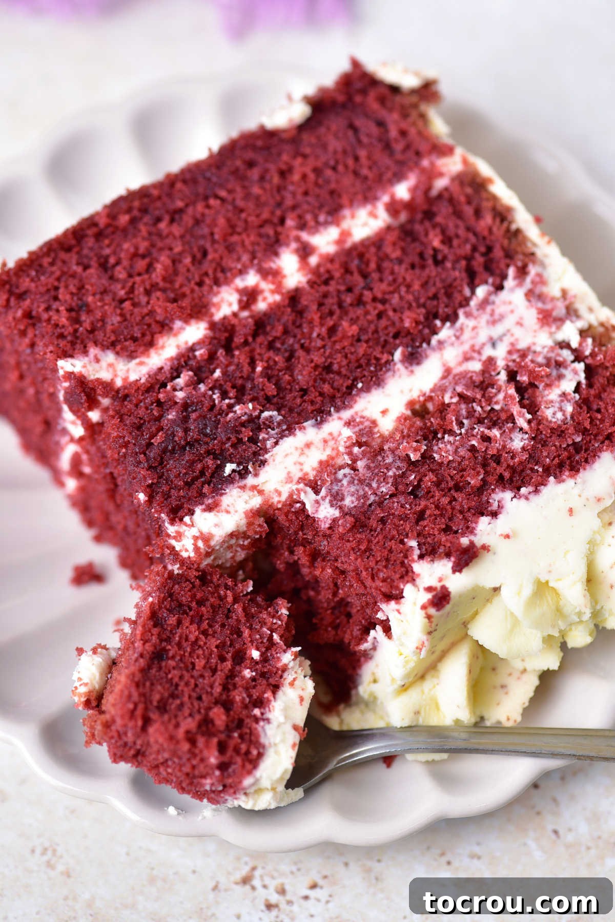 Close-up of a Bite of Red Velvet Cake Close up of a slice of 3 layer red velvet cake with mascarpone frosting with a bite of fluffy cake on a fork ready to eat.