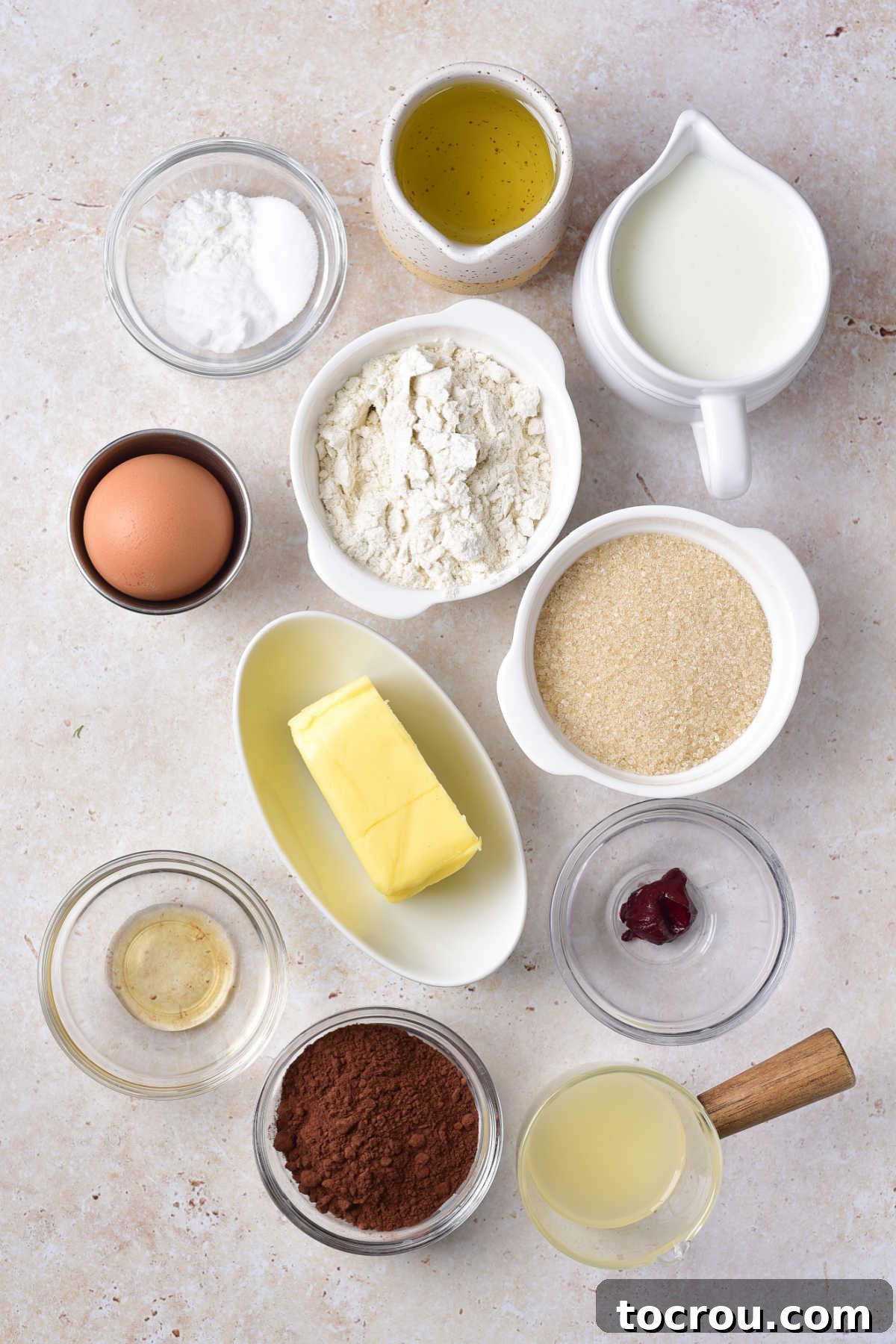 Fresh Ingredients for Red Velvet Cake Ingredients including butter, flour, sugar, eggs, vanilla, cocoa powder, oil, buttermilk, baking soda, and baking powder ready to be made into a red velvet cake.