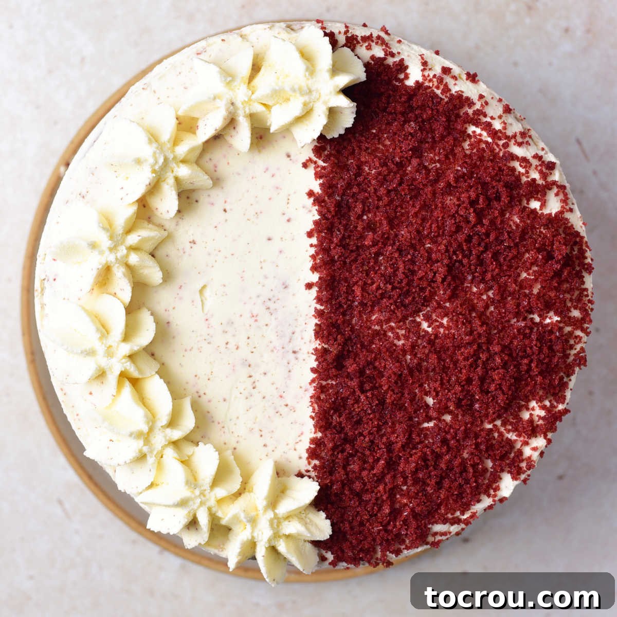 Artfully Decorated Red Velvet Cake with Mascarpone Frosting Looking down on decorated red velvet cake with cake crumbs on one half and piped on mascarpone frosting on the other.