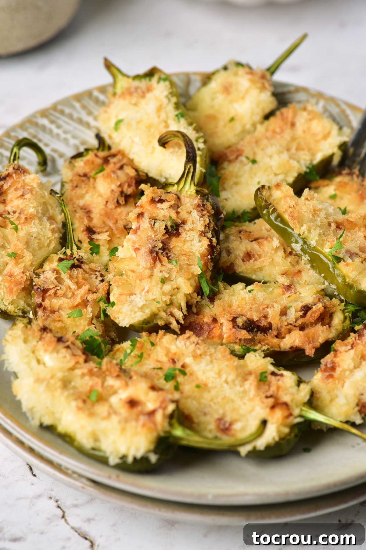 Golden Crispy Jalapeno Poppers Up Close Close up of stuffed jalapenos with cream cheese, cheddar, and bacon filling with crunchy bread crumb topping.