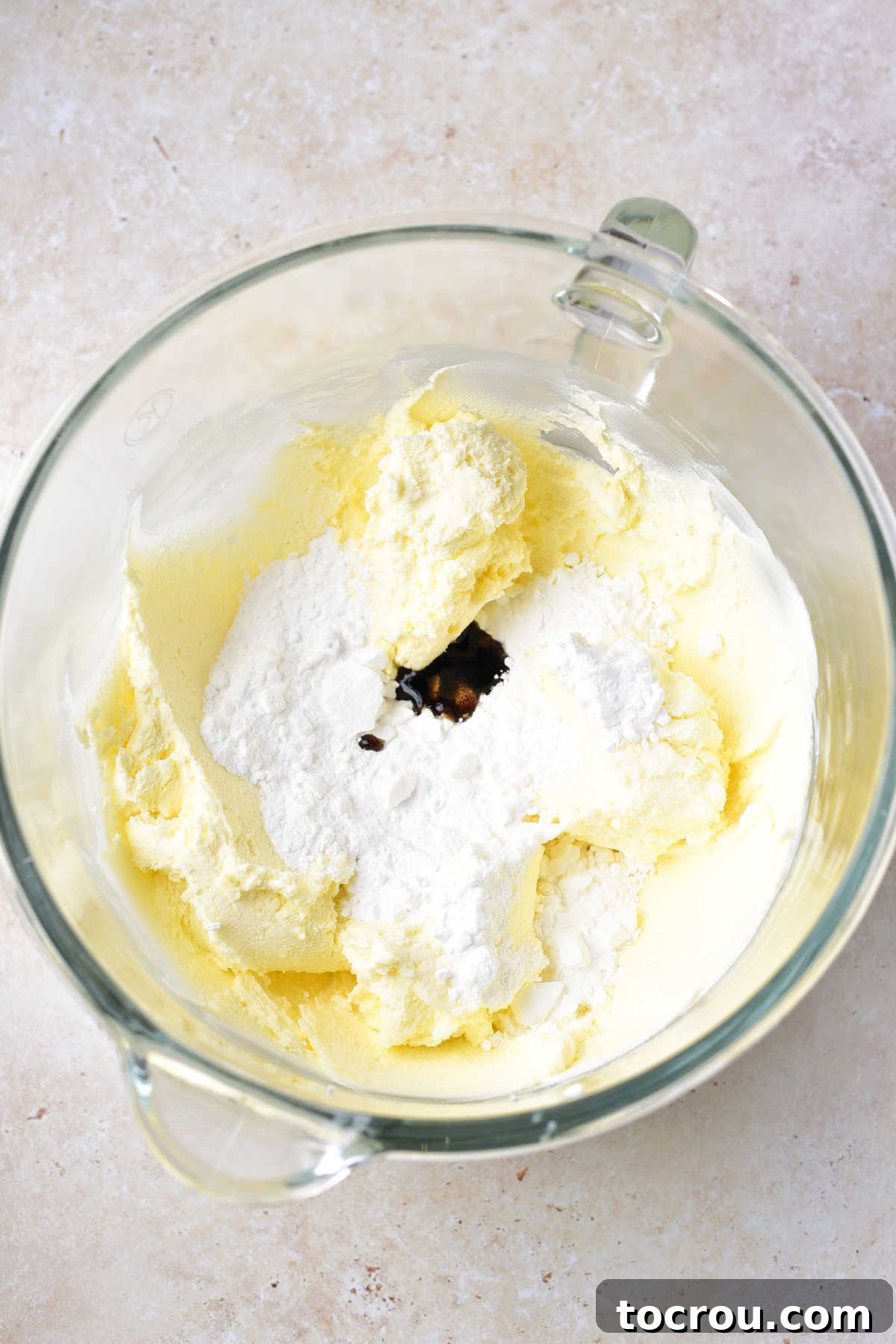 Velvet Mascarpone Frosting 4 Whipped mascarpone and butter in mixer bowl with powdered sugar and vanilla ready to be mixed in.