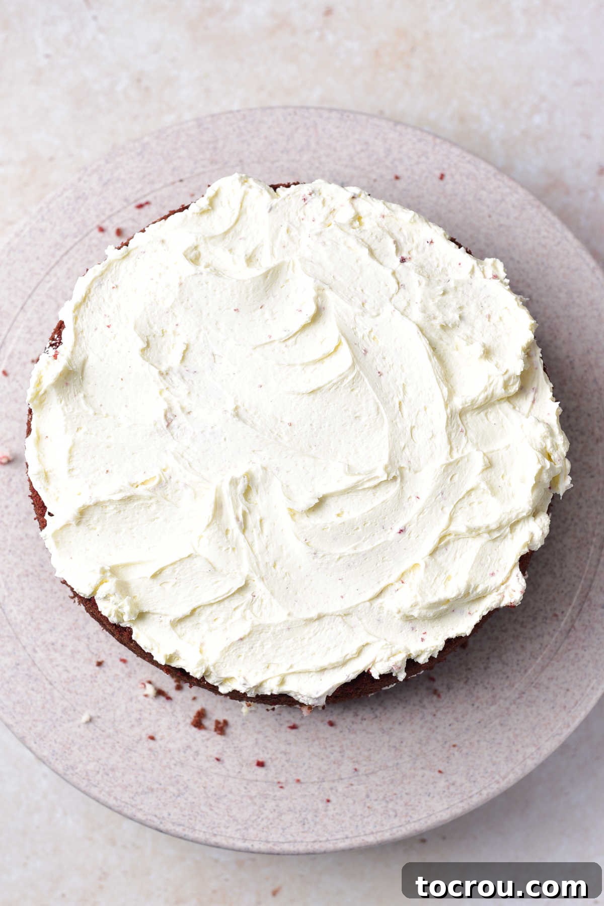 Velvet Mascarpone Frosting 5 Layer of fresh mascarpone frosting spread over bottom layer of a red velvet cake.