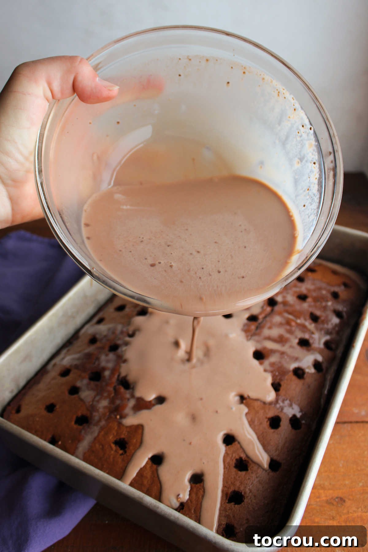 Triple-Milk Chocolate Dream 3 Pour mixture of cocoa powder, sweetened condensed milk, evaporated milk, and whole milk over baked chocolate cake with holes poked in it.