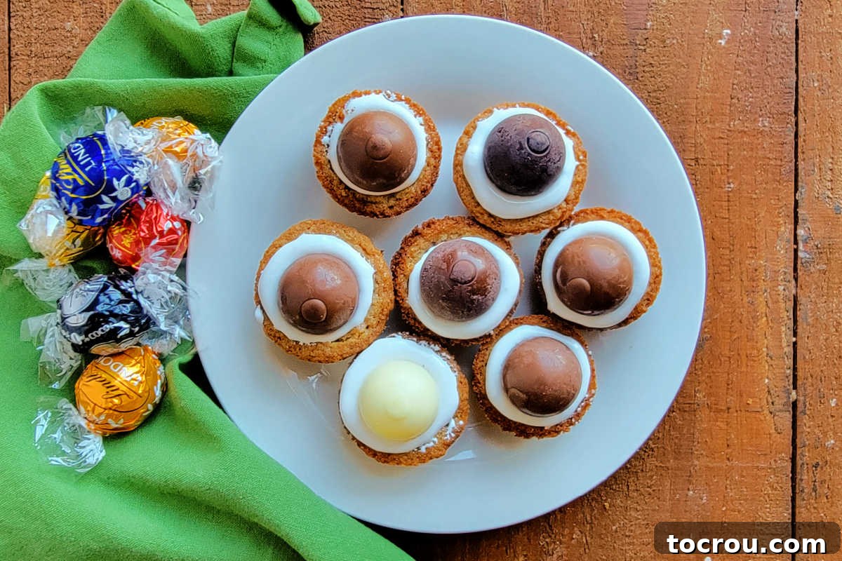 Looking down on a plate of s'mores cookie cups filled with marshmallow fluff and various kinds of chocolate truffles. 