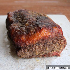 Smoked corned beef flat on cutting board, perfectly rested and ready to be sliced against the grain.