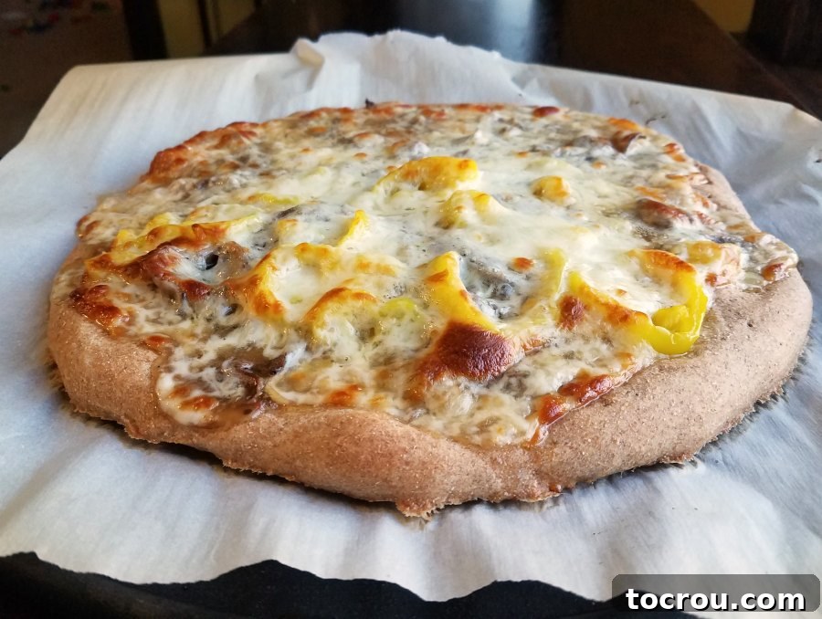 round Italian beef pizza with golden cheese and pepper rings.