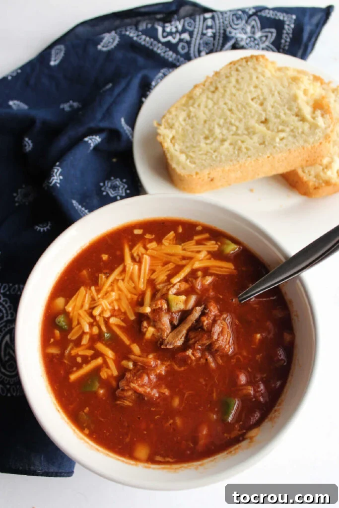 Doris Tangy Cider Loaf 7 Bowl of pulled pork chili topped with cheddar next to plate with slices of beer bread.