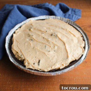 Peanut butter and Oreo pie filling in chocolate pie crust, ready to chill.