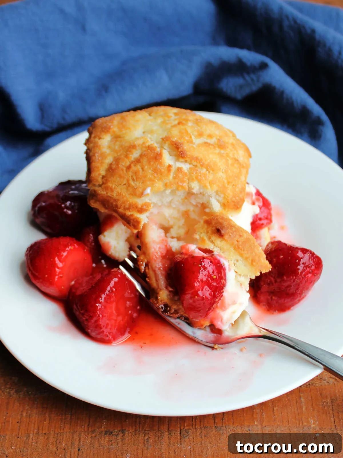 Perfectly Sweet Shortcake Biscuits 4 Fork getting a bite of strawberry shortcake with vanilla ice cream, sweet biscuit, and strawberries.