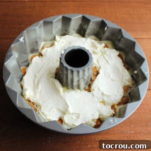 Harvest Pumpkin Bundt Cake with Cream Cheese Core 14 The creamy white cream cheese filling beautifully spread over the first layer of pumpkin cake batter in a Bundt pan, creating a delightful contrast.