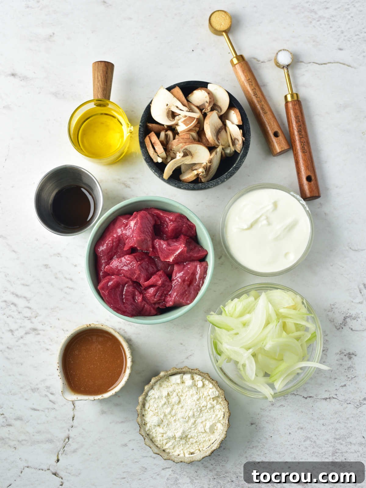 Rustic Venison Stroganoff 3 Ingredients including thin venison strips, mushrooms, onions, beef broth, flour, sour cream, garlic, salt, oil, and worcestershire sauce ready to be made into vension stroganoff.