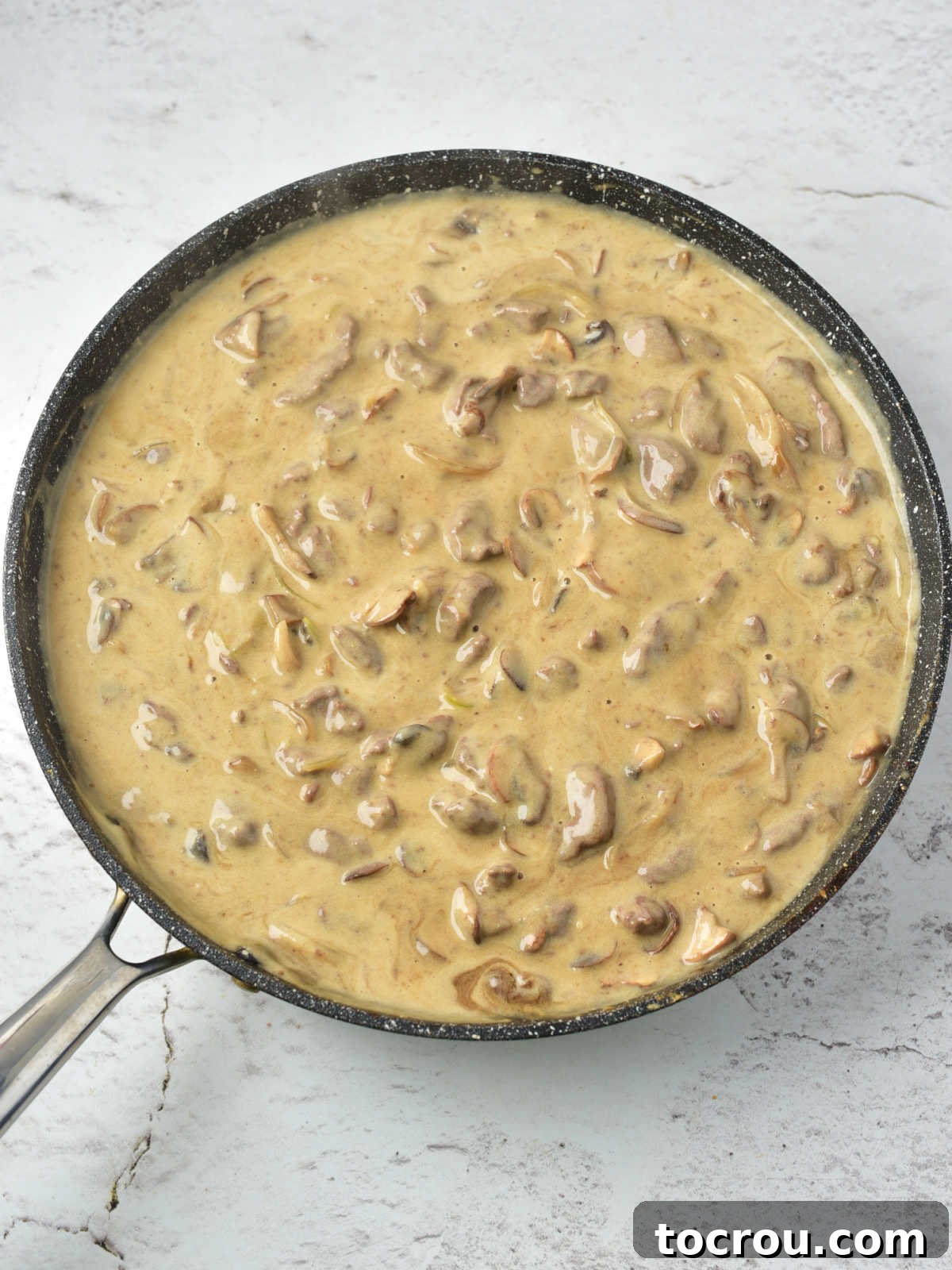 Rustic Venison Stroganoff 4 Pan of creamy venison stroganoff with strips of venison, onions, and mushrooms in creamy sour cream gravy ready to be served.