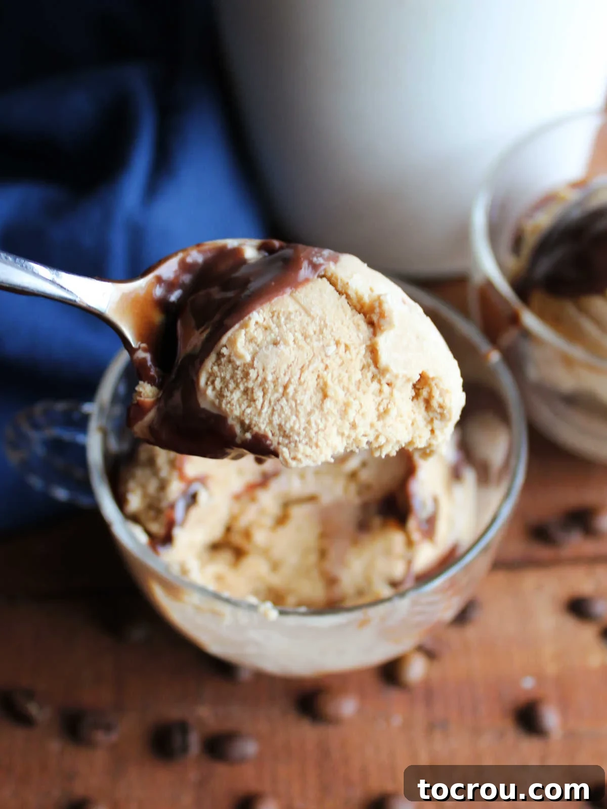 A spoon delicately holding a perfect bite of creamy homemade coffee ice cream, showcasing its smooth texture and readiness for enjoyment.