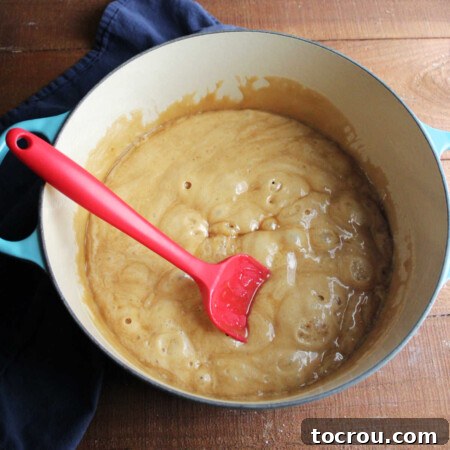 Dutch oven with caramel mixture after baking soda has been stirred in showing how it foams up.