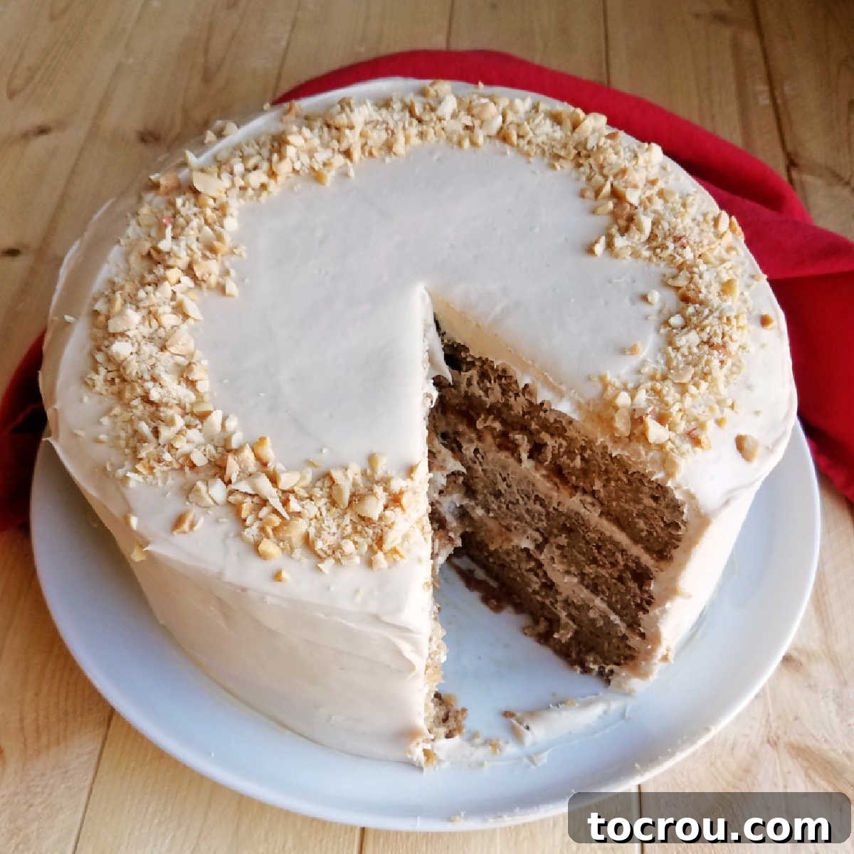 A beautifully layered applesauce cake with soft and creamy caramel cream cheese frosting, a slice missing to reveal the perfectly baked layers.