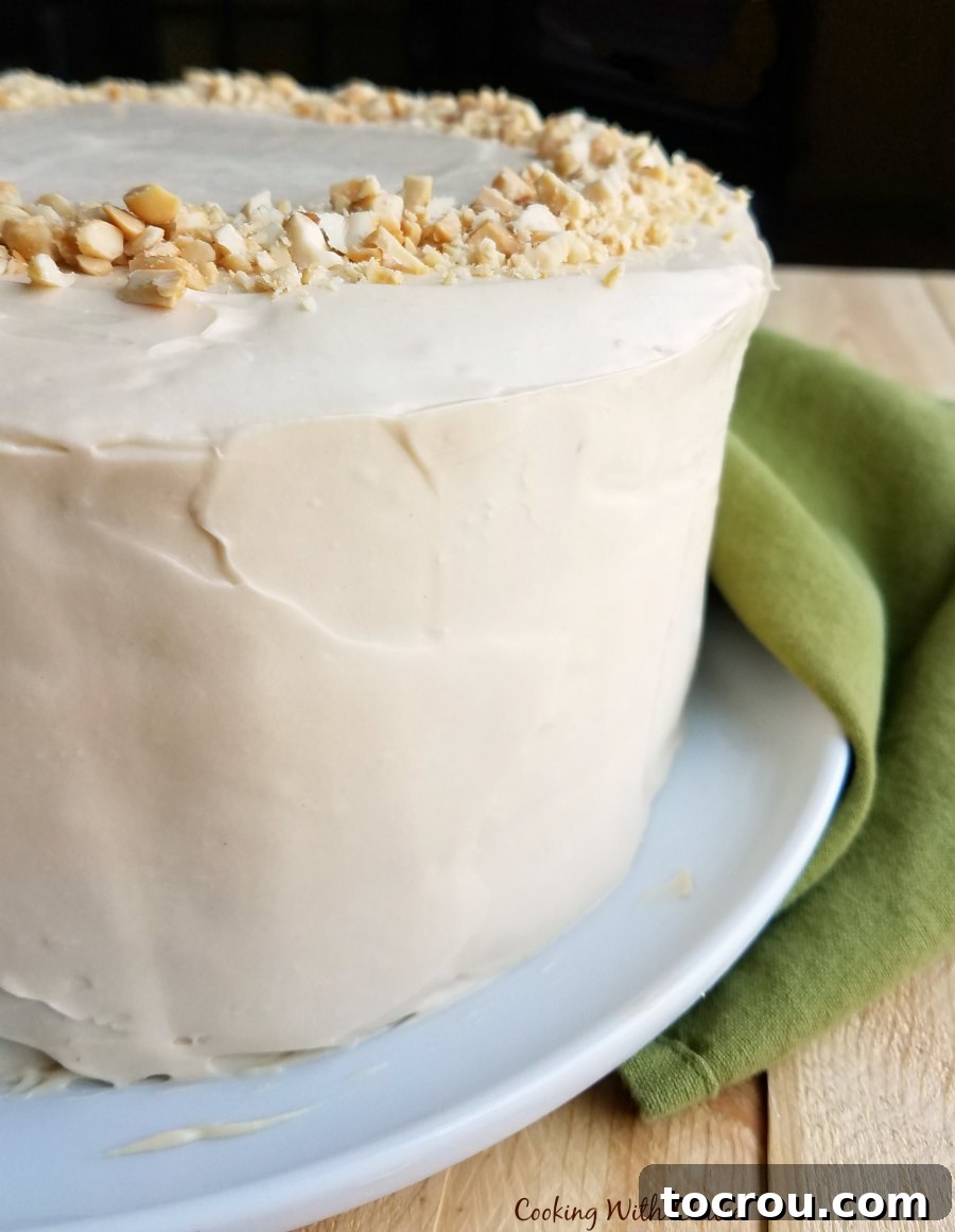 Close-up view of a round layered applesauce cake, beautifully covered with smooth and creamy caramel cream cheese frosting.