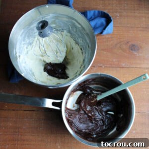 Mixer bowl with whipped butter next to sauce pan of chilled chocolate mixture, poised for combining into frosting.