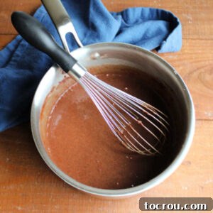 Saucepan after the cold milk has been whisked into the dry ingredients, forming a smooth chocolate liquid.