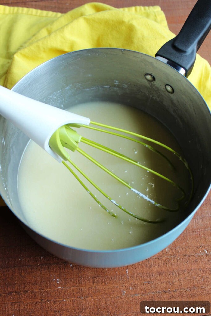 Golden Lemon Crowd Pleaser 4 Saucepan of lemon icing ready to be poured over cake.