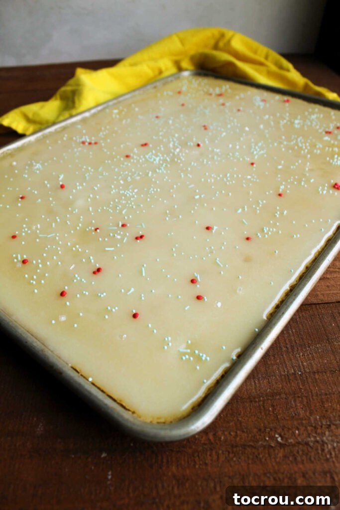 Golden Lemon Crowd Pleaser 6 Sheet pan filled with lemon Texas sheet cake topped with smooth icing and sprinkles.