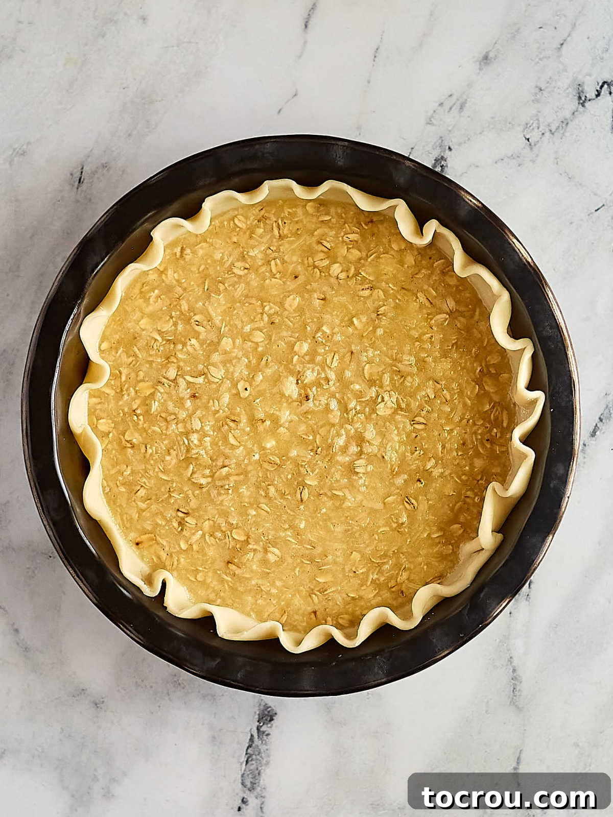 Unbaked oatmeal and coconut pie filling, rich and creamy, nestled perfectly within a delicate pie pastry, poised and ready for its transformation in the warm oven, promising golden deliciousness.