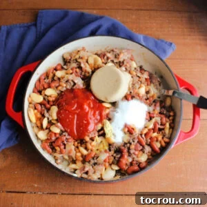 Ketchup, brown sugar, and seasonings added to pan with beans and meat.
