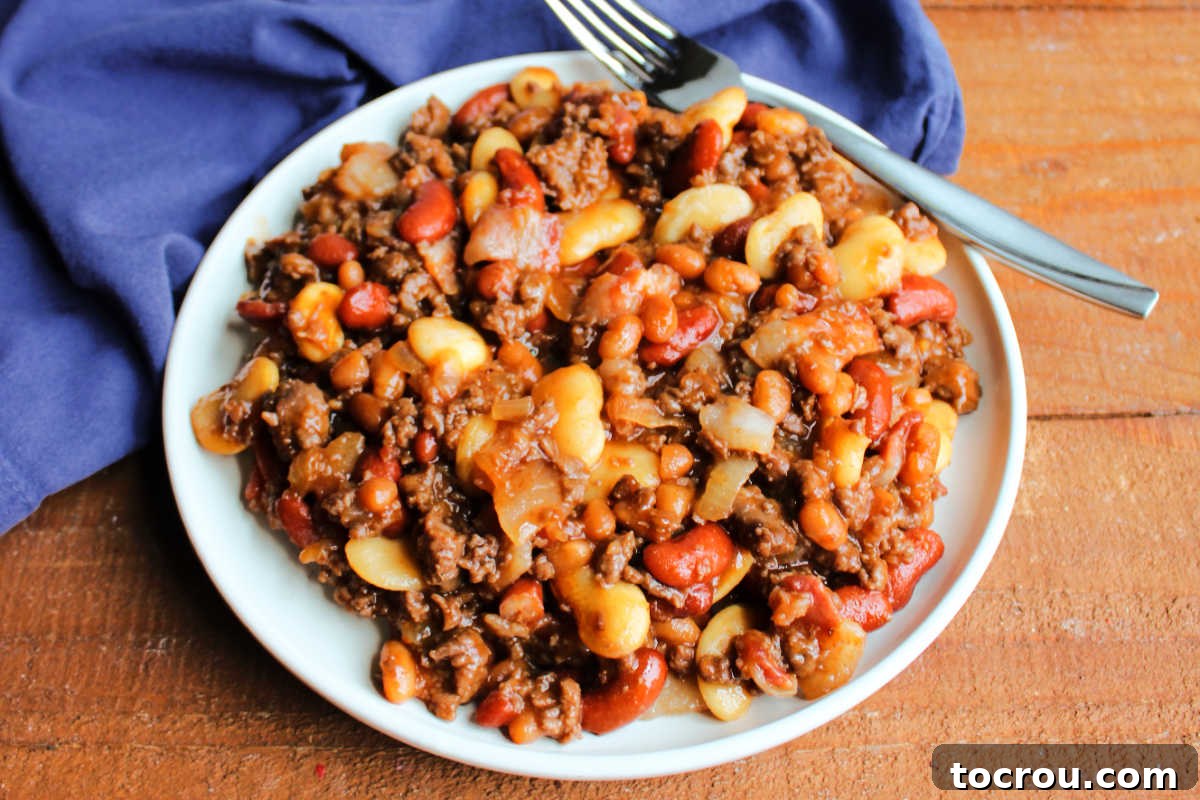 Plate of meaty calico beans with three kinds of beans, ground beef and bacon in a sweet and savory sauce. 