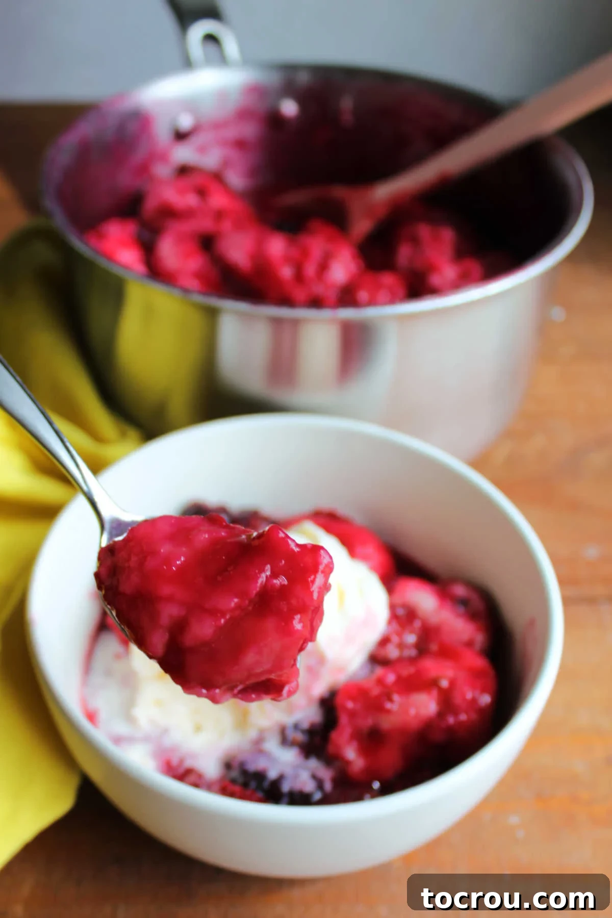 Bite of fluffy purple blackberry dumpling on spoon, ready to eat.