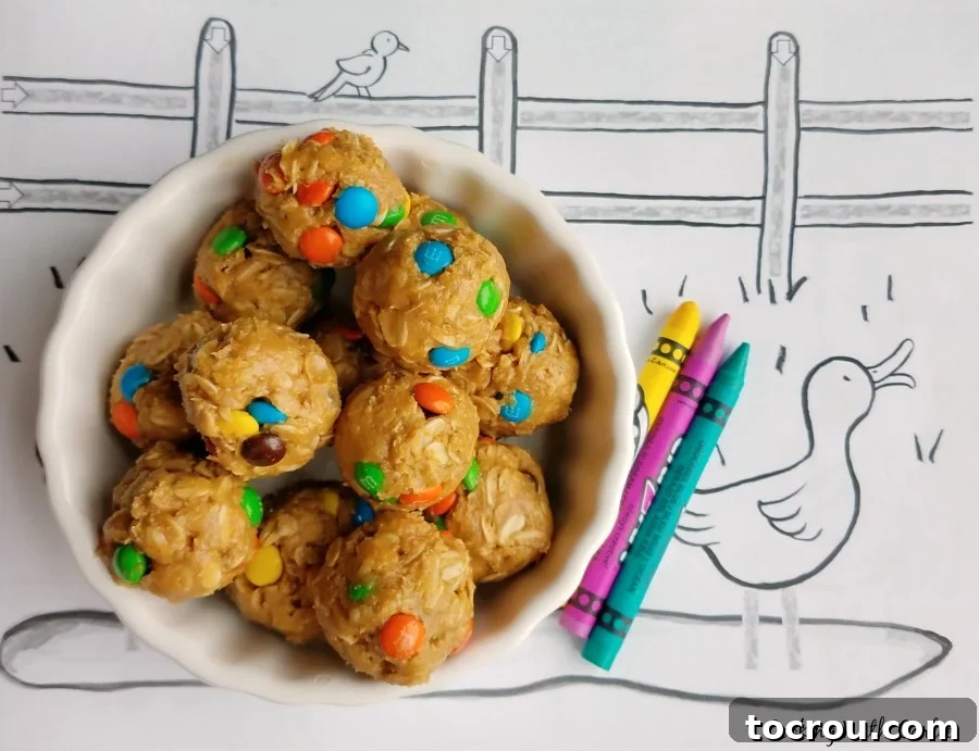 A large bowl brimming with freshly mixed monster cookie dough bites, positioned on a vibrant duck coloring page amidst scattered crayons, suggesting a fun, kid-friendly activity.