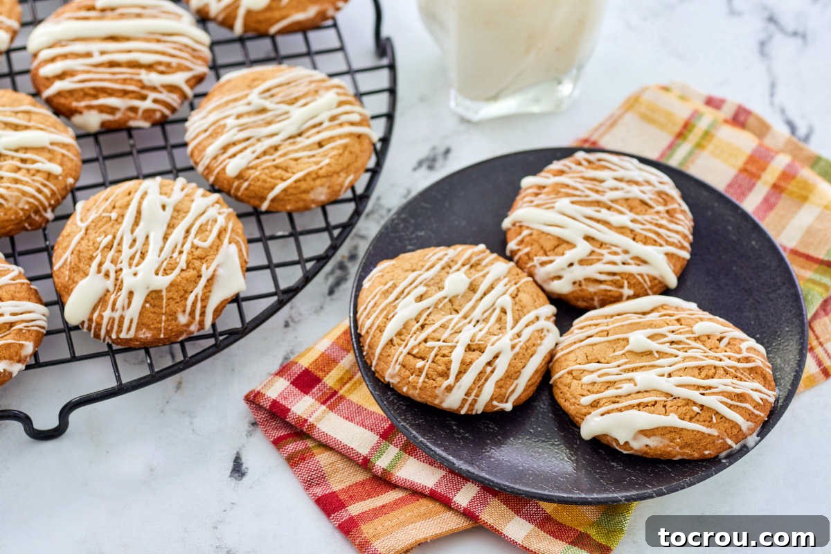Chewy Maple Cinnamon Cookies with Glaze Plate of glazed maple cinnamon cookies next to a glass of milk.