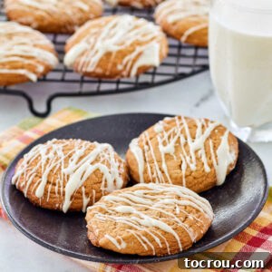 Close up of chewy cinnamon maple cookies on plate next to a glass of milk.