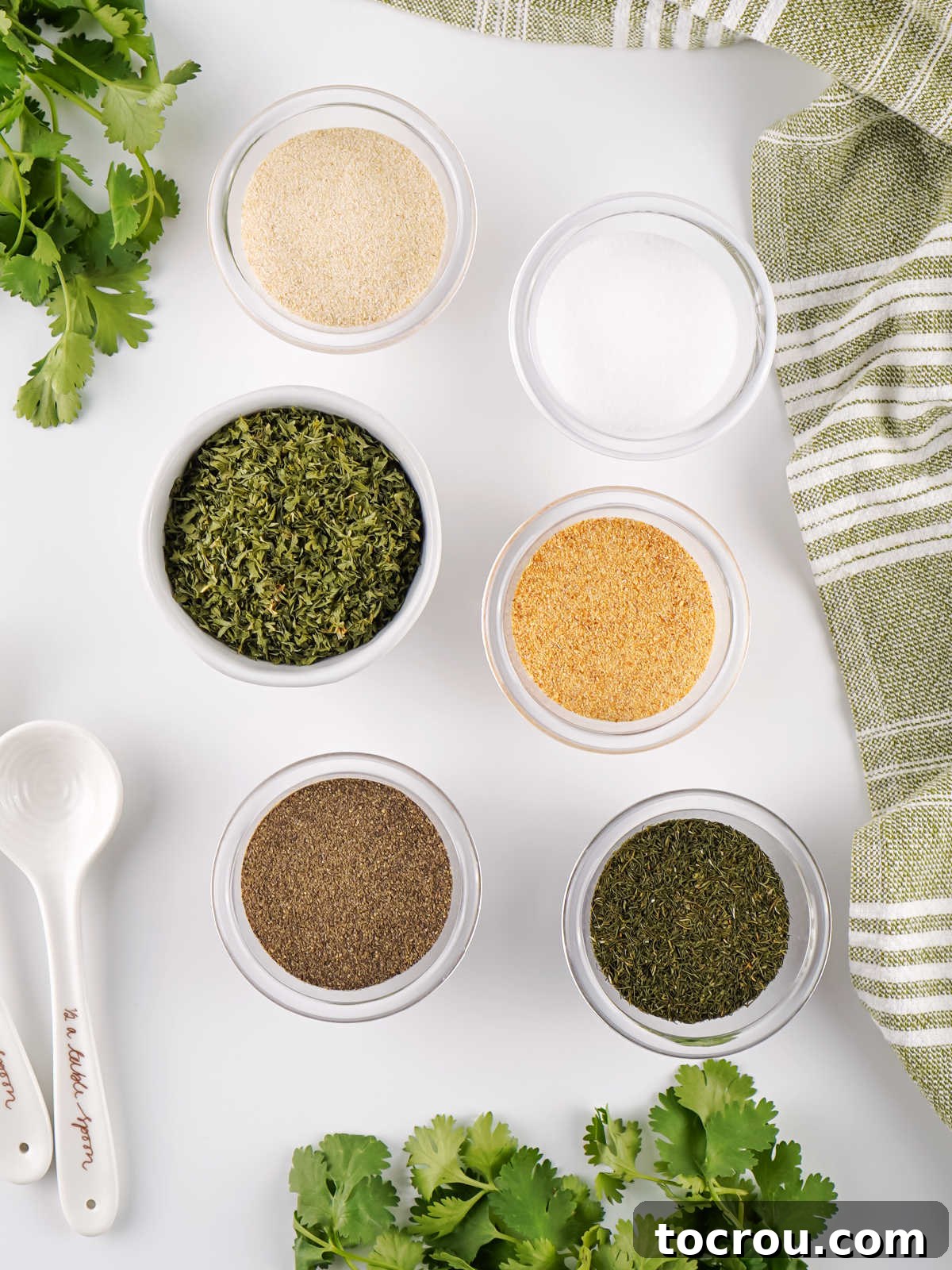 Ingredients including parsley, dill, onion powder, garlic powder, salt and pepper ready to be made into homemade ranch seasoning. 
