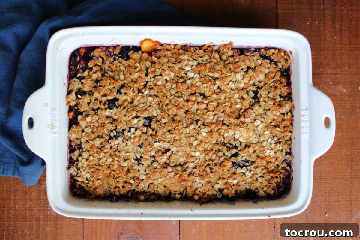 Freshly Baked Blueberry Peach Crisp Baking pan filled with blueberry and peach crisp with brown sugar and oat topping, ready to eat.