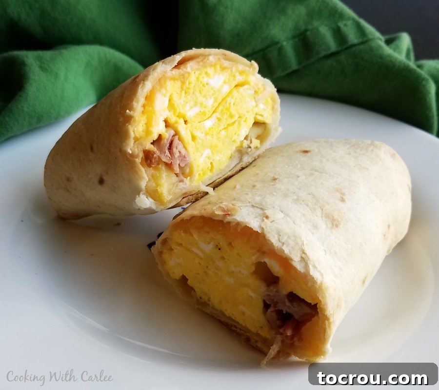 Cross-Section of a Perfectly Baked Breakfast Chimichanga Breakfast chimichanga cut in half to show crispy exterior and a delicious filling of ham, egg, cheese and potato inside.