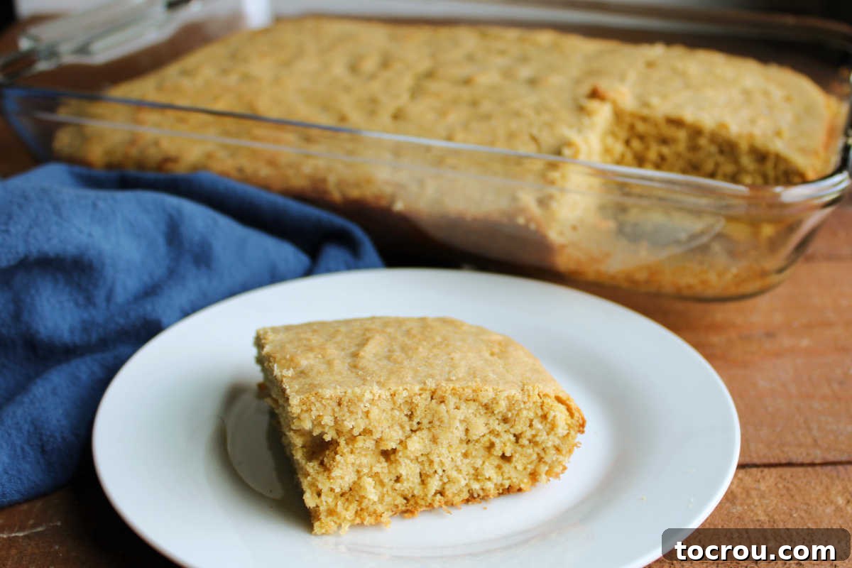 Piece of moist sourdough cornbread on plate, ready to eat.