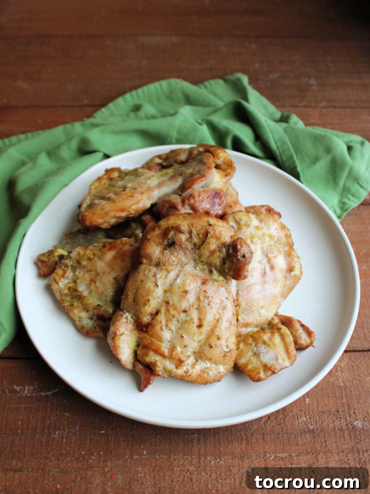 Platter of perfectly cooked boneless, skinless chicken thighs with a beautiful golden-brown char, marinated in a fragrant coconut milk and lime blend.