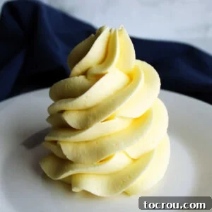 A generous, fluffy pile of pale yellow lemon sweetened condensed milk frosting, perfectly whipped and ready to be spread and enjoyed.