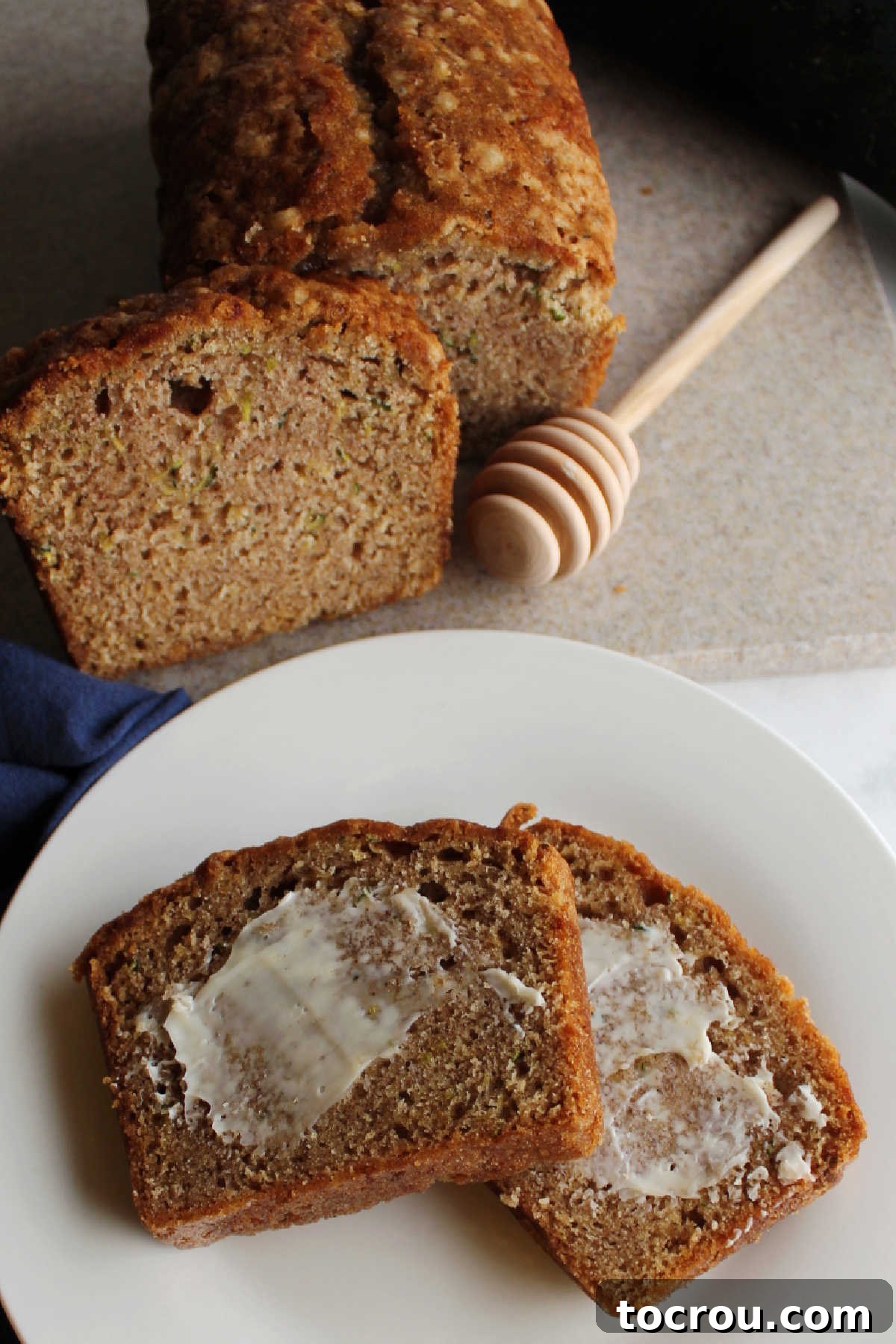 Several slices of zucchini bread beautifully arranged, with butter generously spread on each piece, ready to be enjoyed.