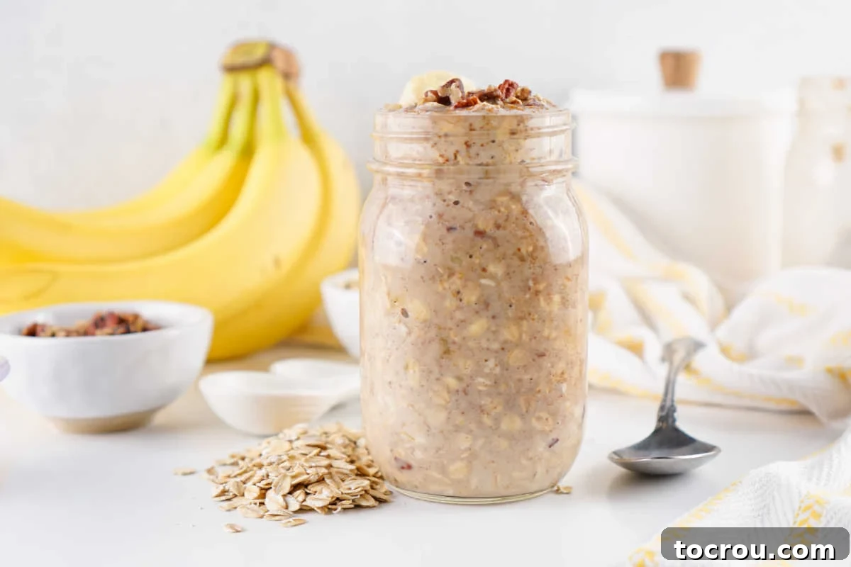 Overnight Banana Bread Bliss 2 Jar of chilled banana bread oats with extra oats nearby and some bananas in the background.