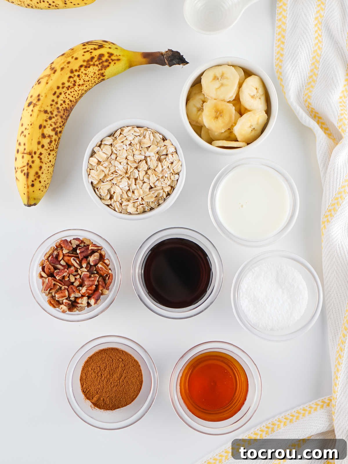 Overnight Banana Bread Bliss 3 Ingredients including a ripe banana, oats, chopped pecans, cinnamon, vanilla, maple syrup, salt, and milk ready to be made into banana overnight oats.